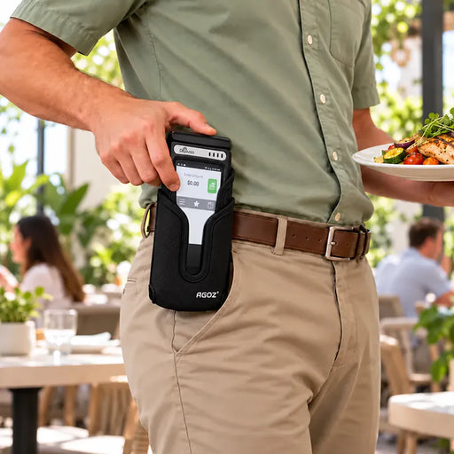 Restaurant worker holding a Dejavoo POS terminal in a black Agoz handheld case while wearing the holster on a belt.