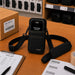 Black AgozTech shoulder sling holster with Janam mobile computer and adjustable crossbody strap.