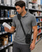 Janam shoulder sling holster worn crossbody by a retail worker reviewing boxed merchandise in an electronics aisle.