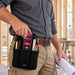 Close-up of construction worker removing a Milwaukee laser distance meter from a black Agoz utility tool pouch attached to his waist belt.