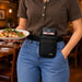 Restaurant server wearing an Agoz waist belt holster with Ingenico POS terminal while carrying a customer meal.
