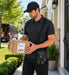 Man delivering a package outside a house with Zebra scanner crossbody case