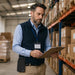 Logistics manager wearing an AgozTech black canvas Cisco IP phone case while reviewing inventory in a warehouse.