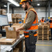 Worker wearing a Unitech HT730UHF waist belt holster while packing orders at a warehouse workstation during RFID inventory control tasks.