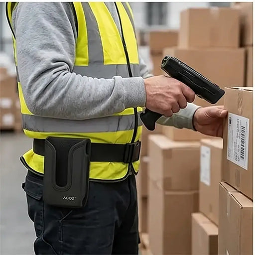 Warehouse worker scanning carton labels with a Panasonic Toughbook trigger scanner while wearing an Agoz belt holster.