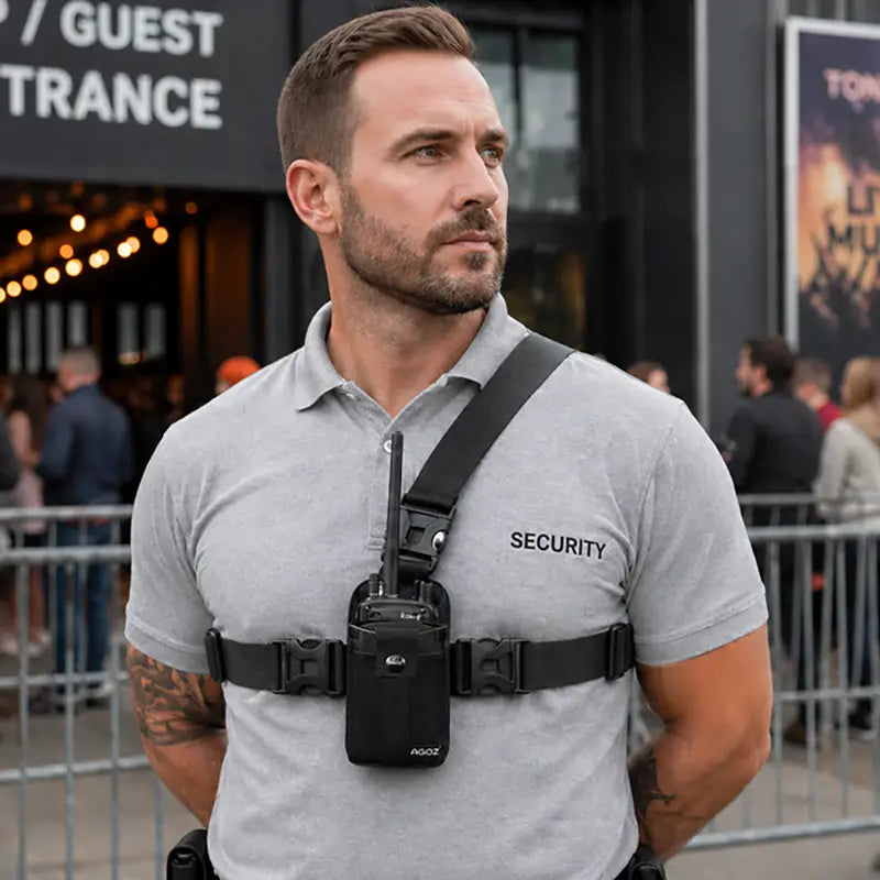Security worker wearing chest harness pouch for L3Harris two-way radio outside a venue