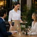 Server using Agoz Durable myPOS handheld case with metal belt clip during tableside restaurant service at outdoor dining table